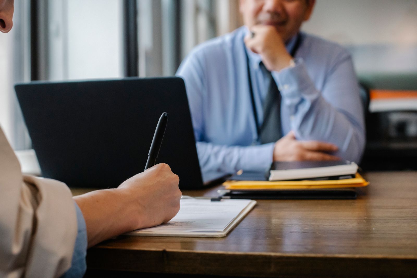 A calm mediation session — a client reviewing and signing an agreement across the table from their mediator.